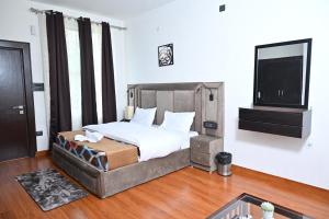 um quarto com uma cama e uma televisão de ecrã plano em The Blossom Glee em Bhīm Tāl