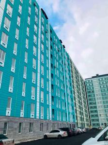 a blue building with cars parked in front of it at Deluxe Spacious Apartment with 1 bedroom , New building, Near City Center in Yerevan
