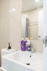 Sathon-Charoen Nakhon Condo في بانكوك: حمام أبيض مع حوض ومرآة +18 صورة