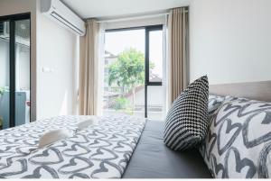 a bedroom with a bed and a large window at Sathon-Charoen Nakhon Condo in Bangkok +24 photos