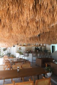 a restaurant with tables and chairs and a straw roof at Bassa nova villa in Panglao