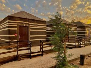 ein kleines Gebäude mit einer Veranda und einer Holztür in der Unterkunft Desert stars in Wadi Rum