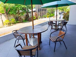 HOTEL TILAMAS في Dares: طاولتين وكراسي مع مظلات على الفناء