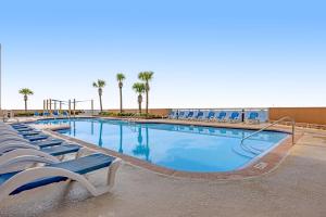 einen großen Pool mit blauen Stühlen und Palmen in der Unterkunft Sunrise Beach Resort 2001 in Panama City Beach