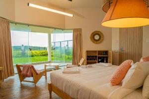 a bedroom with a large bed and a large window at Summer House Resort in Yercaud