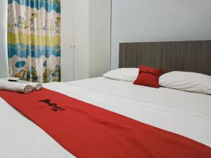 łóżko z czerwonym kocem na górze w obiekcie RedDoorz Syariah At Jalan Doktor Warsito Lampung w mieście Bandar Lampung