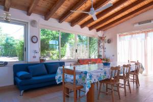 sala de estar con sofá azul, mesa y sillas en Villa Bruffalori, en Sampieri