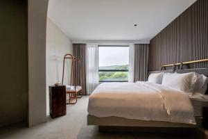 een slaapkamer met een groot bed en een groot raam bij Dengguan Seaview Villa Designer Homestay -Zhoushan Putuo Baisha Island Branch in Zhoushan