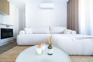 a living room with a white couch and a table at Baltic Pine Retreat W/Balcony, By Cohost in Palanga