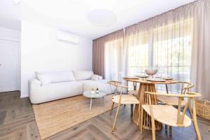 a living room with a white couch and a table at Baltic Pine Retreat W/Balcony, By Cohost in Palanga