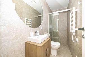 a bathroom with a sink and a toilet and a mirror at Baltic Pine Retreat W/Balcony, By Cohost in Palanga +41 photos