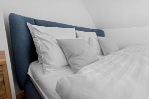 a bed with white sheets and pillows at Stilvolle Wohnung: Private Dachterrasse - zentral in Augsburg