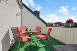 eine Terrasse mit einem Tisch und Stühlen auf dem Balkon in der Unterkunft Stilvolle Wohnung: Private Dachterrasse - zentral in Augsburg