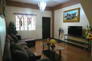 a living room with a couch and a tv at Villa Elsie Resort and Hotel in General Trias