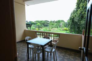 stół i krzesła na balkonie z widokiem w obiekcie Villa Elsie Resort and Hotel w mieście General Trias