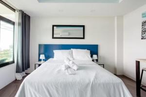 1 cama blanca con cabecero azul en un dormitorio en Casa Noah, en Tagaytay 12 fotos más