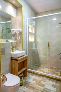 y baño con ducha, aseo y lavamanos. en AL-HAYAT, en Bukhara