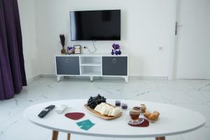 a white coffee table in a living room with a tv at ArtLife apartments FIGA с видом на море in Alanya