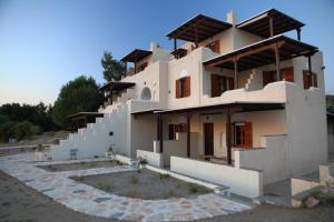 a building with a staircase in front of it at Pirgos Naxos in Aliko Beach