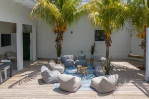 a living room with white furniture and palm trees at Villa CuraLuna in Jan Thiel