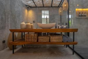 a bathroom with a sink on a shelf with baskets at Elemen Uluwatu Villas in Uluwatu