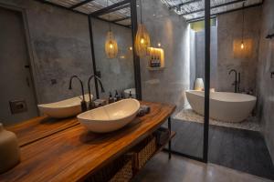 een badkamer met 2 wastafels en 2 badkuipen bij Elemen Uluwatu Villas in Uluwatu