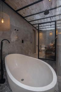 a white bath tub in a bathroom with a room at Elemen Uluwatu Villas in Uluwatu +214 photos
