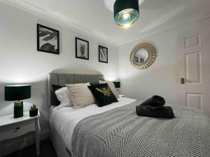 1 dormitorio con cama y espejo en la pared en Rose Court-Free Parking-Central-Long Stay Offer, en Rochester