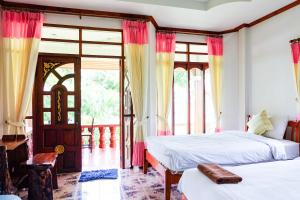 a bedroom with two beds and a window at Mont Goei Pai in Pai