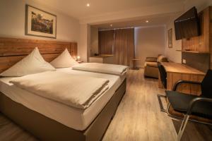 a hotel room with a bed and a desk at Bierenbacher Hof in Nümbrecht