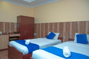 een slaapkamer met 2 bedden met blauwe en witte lakens bij Taj Residency Pokhara in Pokhara