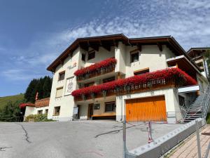 ein Gebäude mit roten Blumen auf der Seite in der Unterkunft Hotel Lucia - 3 Sterne Superior in Damüls