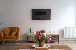 uma sala de estar com uma cadeira e uma mesa com flores em Gîte du Val d'Anglin au calme à 7 km de Le Blanc em Mauvières