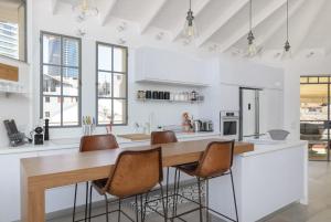 een keuken met een grote houten tafel en stoelen bij Stunning 4BR Duplex Penthouse by HolyGuest in Tel Aviv