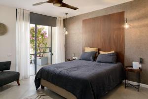 - une chambre avec un grand lit et un ventilateur de plafond dans l'établissement Stunning 4BR Duplex Penthouse by HolyGuest, à Tel Aviv