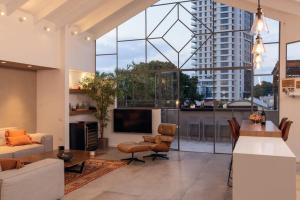 - un salon avec un grand groupe de fenêtres dans l'établissement Stunning 4BR Duplex Penthouse by HolyGuest, à Tel Aviv