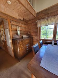 Hirsitalo ja -sauna في Nummi: غرفة طعام مع طاولة وجدار خشبي