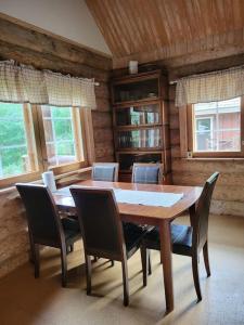Hirsitalo ja -sauna في Nummi: غرفة طعام مع طاولة وكراسي خشبية