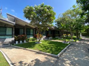 a house with a yard with trees and grass at Family House Zen Boutique Resort in Pai