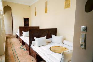 una fila de camas alineadas en una habitación en Riad Dar Zaouia en Marrakech