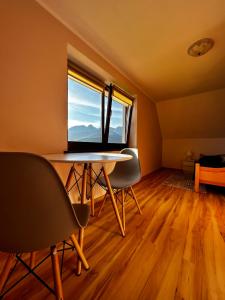 une pièce avec une table et des chaises et une grande fenêtre dans l'établissement Z widokiem na Giewont, à Kościelisko