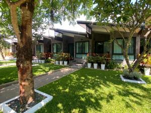a house with a tree in the yard at Family House Zen Boutique Resort in Pai