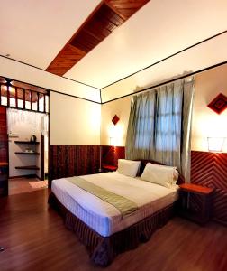 ein Schlafzimmer mit einem großen Bett in einem Zimmer in der Unterkunft Sepilok Jungle Resort in Sepilok