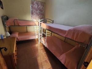 um pequeno quarto com 2 beliches em Casa Rural Mesa Del Lobo Cabrahigo em Sevilha