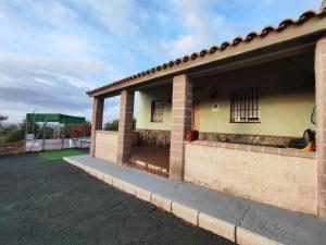 uma vista lateral de uma casa com um parque infantil em Casa Rural Mesa Del Lobo Cabrahigo em Sevilha