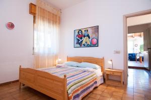 1 dormitorio con 1 cama y una pintura en la pared en Villa Bruffalori, en Sampieri