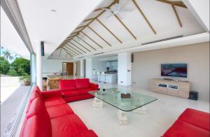 sala de estar con sofá rojo y mesa de cristal en White Tiger Villa, en Koh Samui 