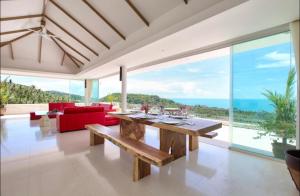 a dining room with a table and a view of the ocean at White Tiger Villa in Koh Samui 