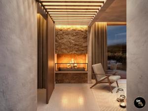 a living room with a fireplace and a chair at Banyan Tree Veya, Valle de Guadalupe in Valle de Guadalupe