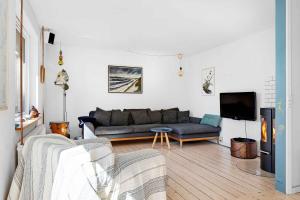 sala de estar con sofá y TV en Fjordlyst en Holbæk